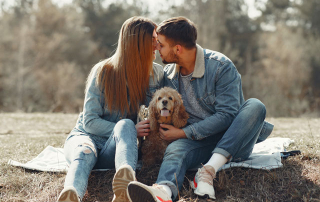 couple en train de s'embrasser à côté de leur chien