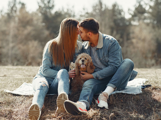 couple en train de s'embrasser à côté de leur chien