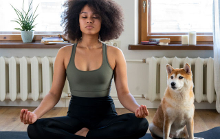 FEMME FAISANT DU YOGA AVEC SOIN CHIEN