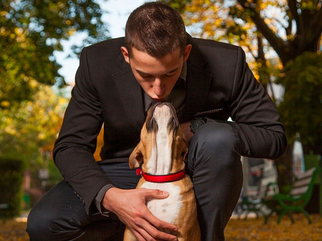 Homme embrassant un chien sur la tête