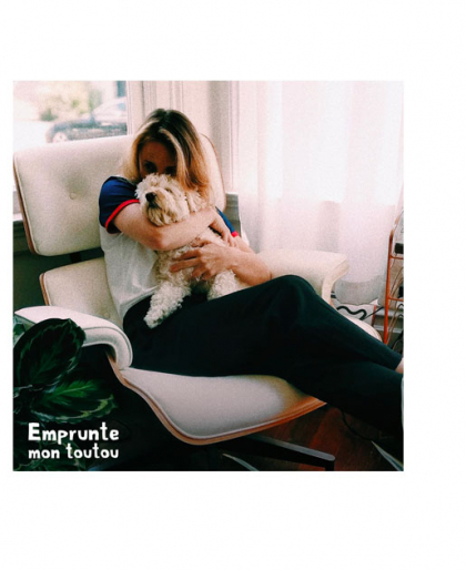 jeune femme assise dans un fauteuil tenant un chien dans ses bras
