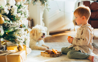 ENFANT ET SON CHIEN DEVANT UN SAPIN DE NOEL