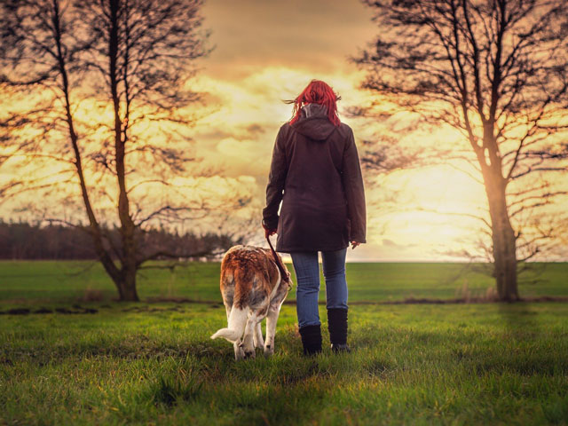 FEMME MARCHANT AVEC UN CHIEN