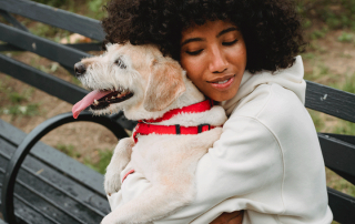 FEMME TENANT UN CHIEN DANS SES BRAS