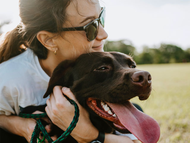 jeune femme enlaçant un chien