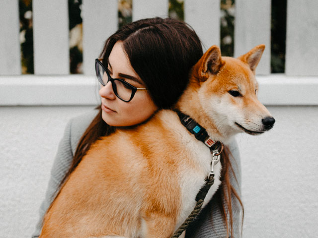 femme enlaçant un chien shiba inu