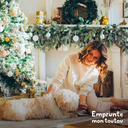 femme caressant un chien dans un décor de Noël