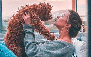 femme tenant son chien dans ses bras