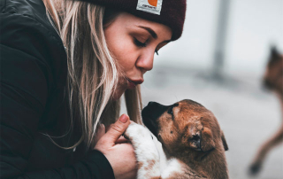 jeune femme embrassant un chiot