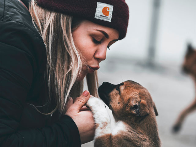 jeune femme embrassant un chiot