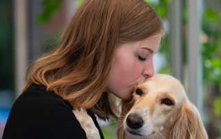 jeune femme embrassant un chien