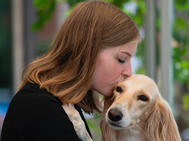 jeune femme embrassant un chien